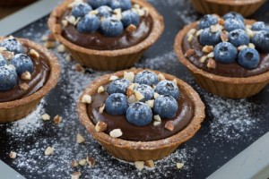 chocolate mousse with fresh blueberries and nuts in tartlets, horizontal, close-up